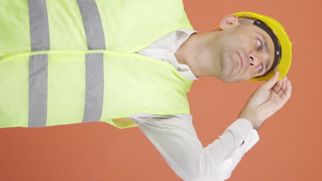 Vertical-video-of-Looking-up,-the-engineer-is-holding-his-hard-hat.